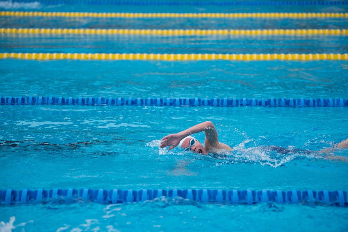 Young swimmer doing front crawl in a pool lane