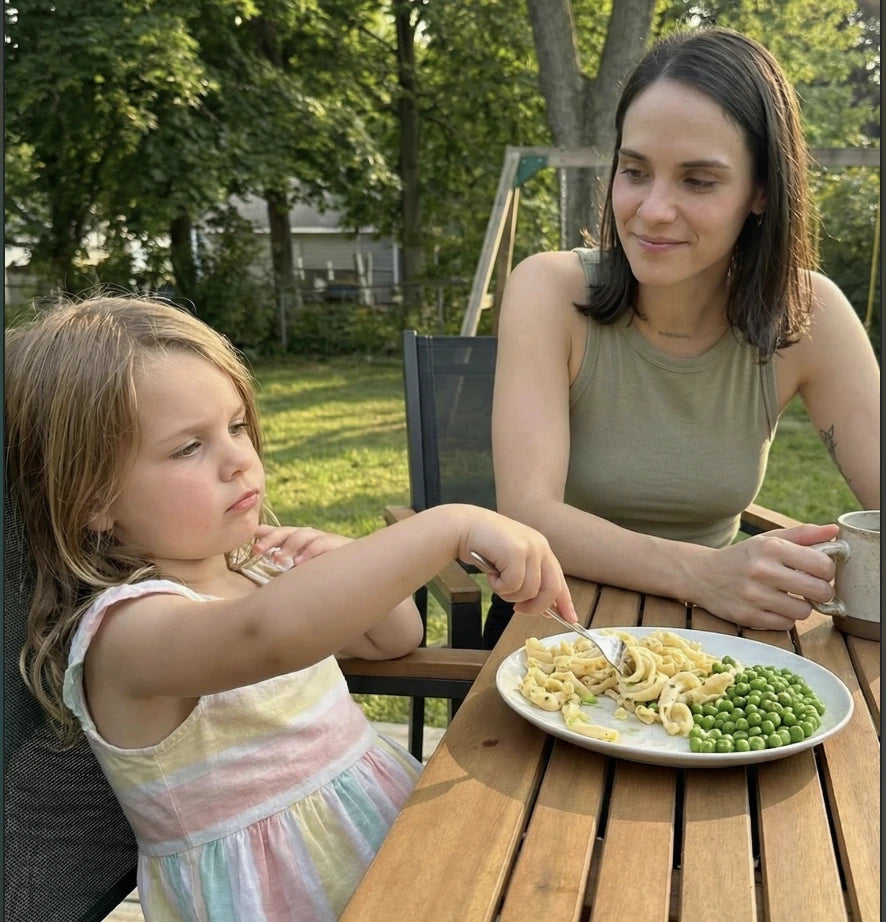 Child pushing away a plate of vegetables at dinner